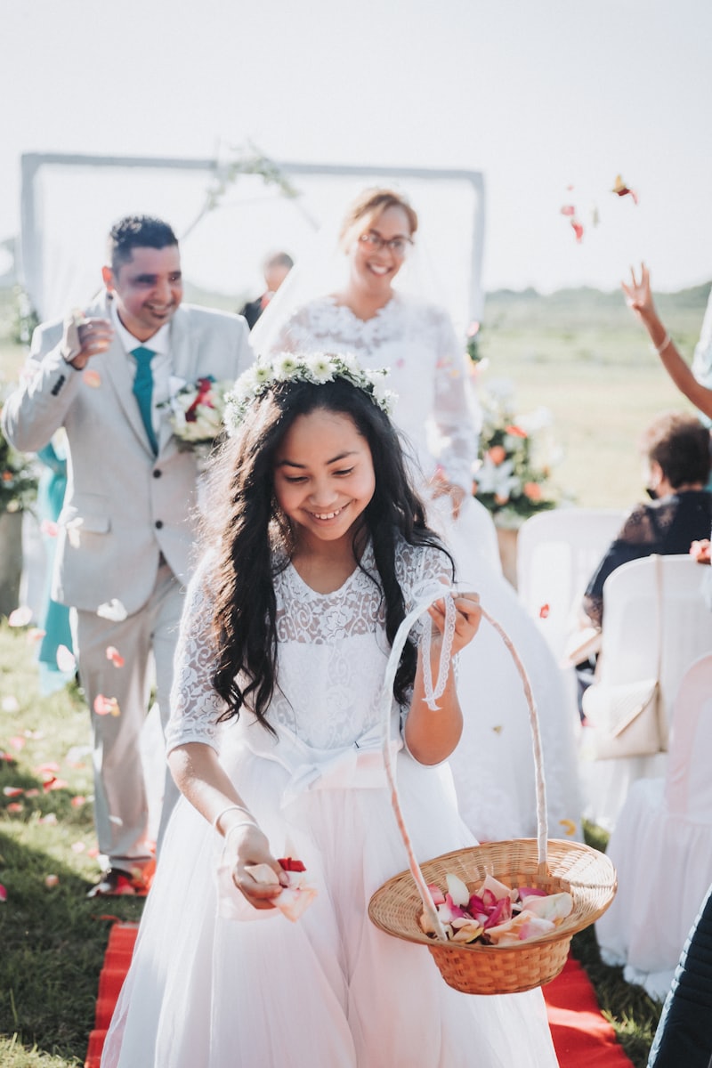 A flower girl walking the aisle with a basket of petals